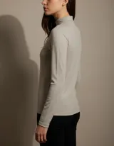 Polera de manga larga con cuello alto, confeccionada en tejido de lanilla de textura suave y ajuste entallado.