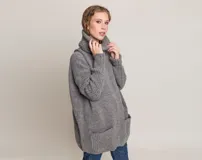 Sweater gris de lana merino con cuello alto y bolsillos delanteros.