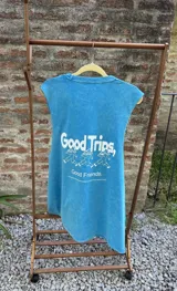 Musculosa sin mangas color azul vibrante con un gráfico estampado en blanco de una figura antropomórfica con cabeza de hongo, en pose de baile o carrera.