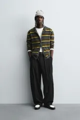 Pantalón de corte balloon fit en color gris, confeccionado en tejido con viscosa. Presenta pliegues frontales, cintura con cinturón integrado a contraste, bolsillos laterales y bolsillos traseros de vivo.