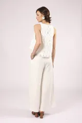 Blusa blanca de broderie con cuello redondo y sin mangas.
