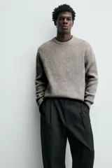 Sweater de punto color beige, de corte relajado, con cuello redondo y diseño texturizado en estructura waffle.