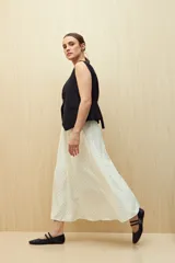 Falda midi color blanco con estampado de lunares negros.