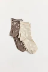 Pack de dos pares de medias cortas con diseño de corazones. Un par es de color marrón con corazones blancos contorneados y el otro par es de color beige con corazones blancos rellenos. Ambas cuentan con el logo de la marca estampado en la planta.