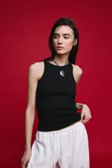Musculosa de calce ajustado confeccionada en algodón con elastano, con textura acanalada y escote redondo alto.