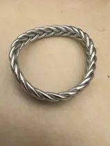 Pulsera de resina flexible con diseño trenzado y acabado brillante, con relleno de lámina metálica en tonos dorados, plateados y cobrizos.