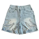 Short de jean estilo bermuda con diseño de llamas desflecadas en el frente. Presenta un lavado claro, corte recto y tiro bajo.