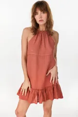 Vestido corto verde militar de lino, con escote halter fruncido en el cuello y detalle de volados en el ruedo.