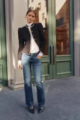 Jeans de tiro bajo y cintura ancha, con diseño bootcut de corte evasé desde la rodilla. Cuenta con cinco bolsillos y cierre frontal con cremallera y dos botones metálicos. Color azul con efecto desgastado.
