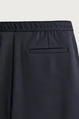 Bermuda regular fit de tejido elástico color blanco, con cintura elástica ajustable mediante cordón, bolsillos delanteros y bolsillos traseros de vivo.