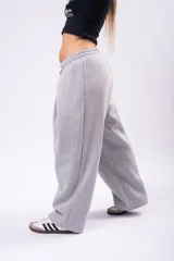 Pantalón de estilo deportivo confeccionado en tela con friza, de corte ancho y tiro medio con cintura elástica y cordón de ajuste.