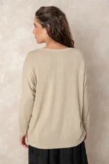 Buzo de punto ligero con acabado metalizado, color beige dorado, con escote en V, mangas largas y corte relajado.