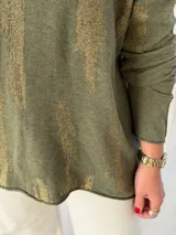 Sweater de punto color verde oliva con estampado de pinceladas doradas brillantes, escote en V y mangas largas con diseño holgado.