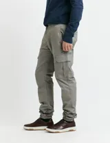 Pantalon cargo de corte ajustado en color verde grisáceo, con bolsillos laterales con solapa y puños elásticos en los tobillos.