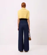Pantalón wide leg de jean azul oscuro, de talle alto con calce amplio y detalles de botones dorados en el lateral frontal.