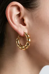 Aros tipo argolla dorados de diseño en espiral gruesa.