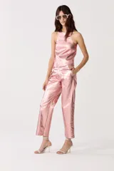 Pantalón de lino metalizado color rosado, de corte recto, tiro medio y bolsillos laterales.