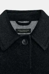 Chaqueta de corte recto confeccionada en mezcla de lana, color negro. Presenta cuello solapa, manga larga y cierre frontal con botones a tono.