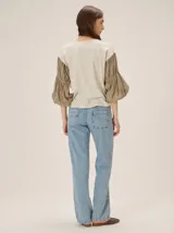 Remera blanca con cuerpo de algodón liso y mangas abullonadas semitransparentes con textura de lunares.