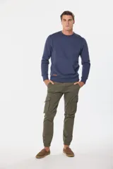 Pantalón cargo azul marino con bolsillos laterales con solapa y cinturón de cuero marrón.