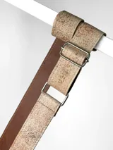 Correa ajustable para cartera confeccionada en cuero, con diseño pintado a mano en tono beige con textura moteada y reverso en cuero liso color marrón. Incluye herrajes metálicos plateados.