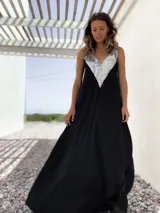 Vestido largo de fiesta color negro, con escote en V profundo decorado con lentejuelas plateadas y breteles anchos.