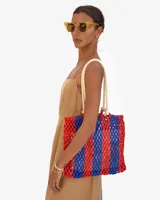 Bolso tote bag tejido a crochet con rayas verticales en color rojo y azul.