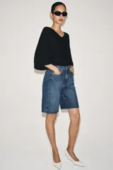 Bermuda de denim color bordó, de tiro medio y corte relaxed, con diseño de cinco bolsillos, trabillas para cinto y bajo desflecado.