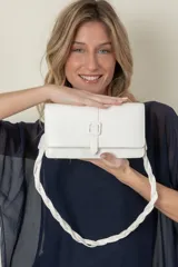 Cartera rectangular color blanco de símil cuero, con correa corta trenzada y correa larga lisa.
