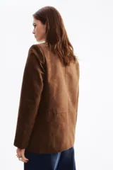 Blazer cruzado marrón con acabado cepillado, solapas de muesca, hombreras y bolsillos delanteros con solapa. Diseño con doble botonadura.