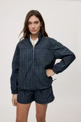 Campera liviana de calce relajado con estampado a cuadros en tonos de azul y verde. Cuenta con cuello alto, cierre frontal y mangas largas.
