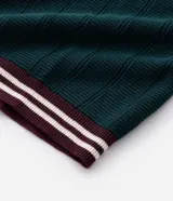 Polo de manga corta confeccionado en tejido de punto texturizado con trama vertical. Presenta cuello, puños y ruedo en color bordó con detalles de rayas blancas en contraste. Cuenta con una abertura frontal con tres botones.