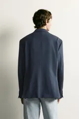 Blazer regular fit azul marino confeccionado en tejido con elasticidad, con cuello de solapas de muesca, cierre frontal con botones y bolsillos con solapa en la cadera.