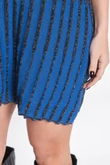 Vestido corto de punto con brillo, sin mangas, cuello redondo y diseño a rayas verticales en tonos azul y negro.