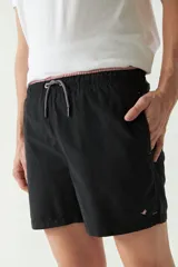 Short de baño liso de corte clásico, con cintura elástica ajustable mediante cordón. Cuenta con dos bolsillos laterales y uno trasero, confeccionado en tejido ligero de secado rápido con logo bordado.