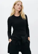 Camiseta básica de manga larga en tela acanalada, color negro, con cuello redondo.