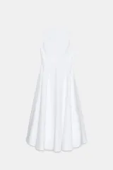 Vestido midi de color blanco con escote halter, tirantes finos ajustables con lazos en los hombros, corte ajustado en la cintura y falda acampanada con volumen.