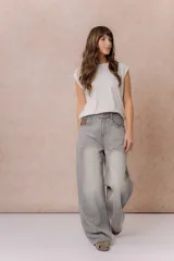 Jean wide leg de tiro alto color gris con efecto lavado desgastado, corte holgado, diseño de cinco bolsillos y cierre frontal con botón y cremallera.