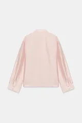 Camisa satinada de manga larga con cuello redondo y cierre frontal con alamares. Cuenta con bolsillos de plastrón en el frente y diseño de corte recto.