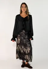 Pollera midi de corte al bies con estampado tie-dye en tonos negro y beige. Confeccionada en tejido fluido con caída suave.