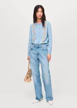 Cardigan de punto fino en color celeste con diseño de rombos en tonos beige. Presenta cuello redondo, cierre frontal con botones y mangas largas.