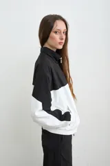 Campera estilo aviador de tela avión, en diseño bicolor negro y blanco, con cierre frontal y cuello alto. Cuenta con bolsillos laterales con cierre y bordado de la marca Mandinga en el pecho.