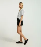 Remera de media malla blanca con rayas horizontales negras, cuello alto y mangas cortas.