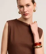 Vestido midi de algodón color marrón, con escote bote, sin mangas y con ligero drapeado lateral.