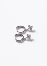 Aros tipo argolla con dije colgante en forma de flor compuesto por zirconias brillantes. Fabricados en plata 925.