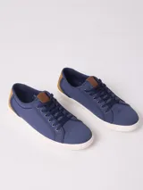 Championes azules de lona con detalles en cuero sintético color marrón y suela blanca de goma.