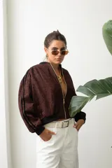 Campera bomber de gamuza con estampado animal print en tono bordó, cierre frontal dorado y puños y cintura de tejido elástico negro.