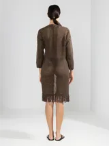 Cárdigan largo de algodón color crudo, tejido con punto abierto y detalles de flecos en el ruedo.