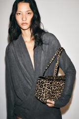 Bolso de hombro de piel con textura, diseño de estampado animal print, doble asa de hombro, bolsillo interior con cremallera y cierre mediante solapa con botón imantado.