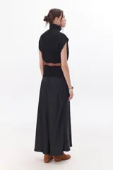 Falda larga color beige confeccionada en satén, de corte recto y cintura elastizada.